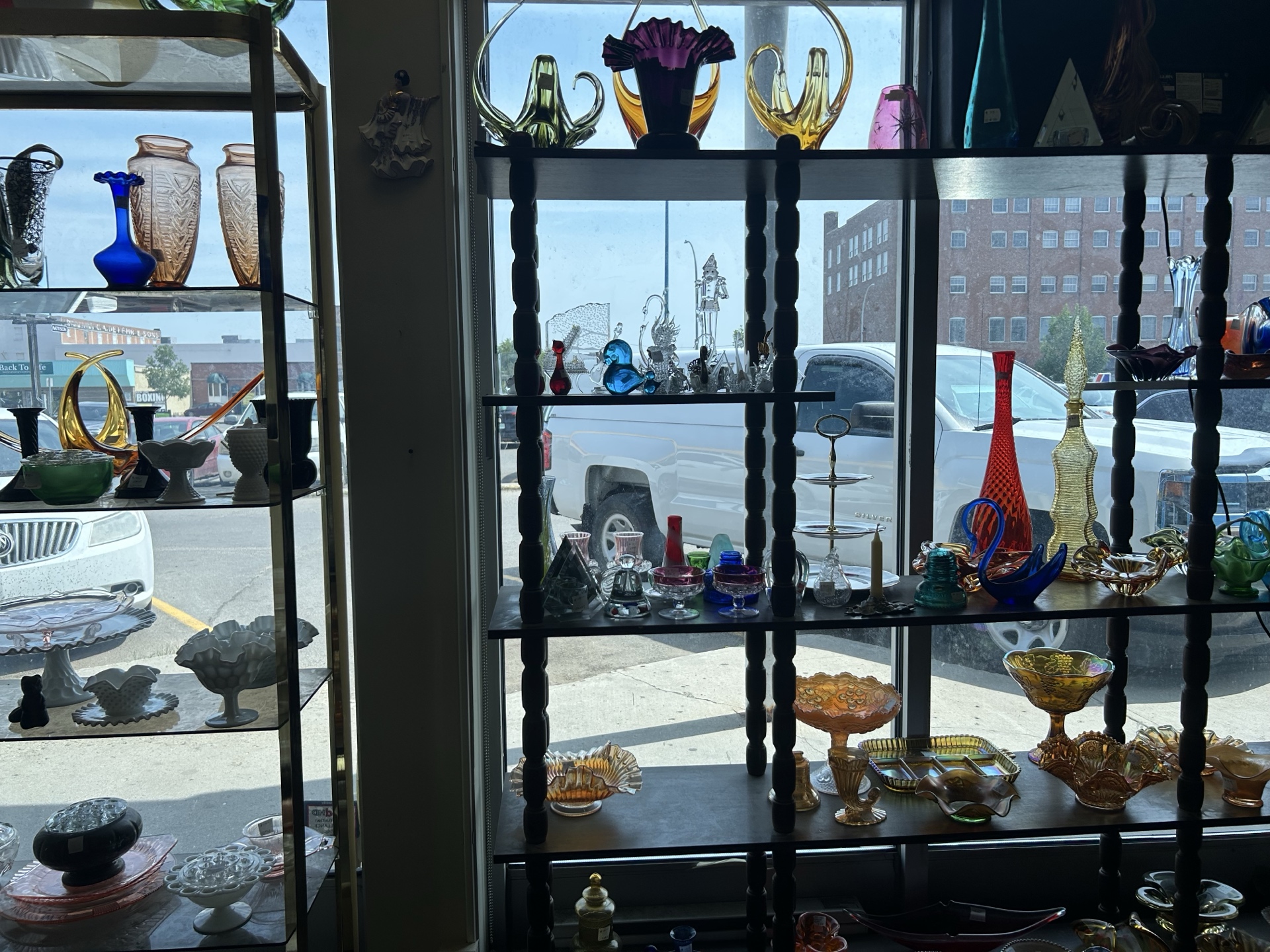 Colorful vintage glassware displayed in window at Krave Antiques Regina