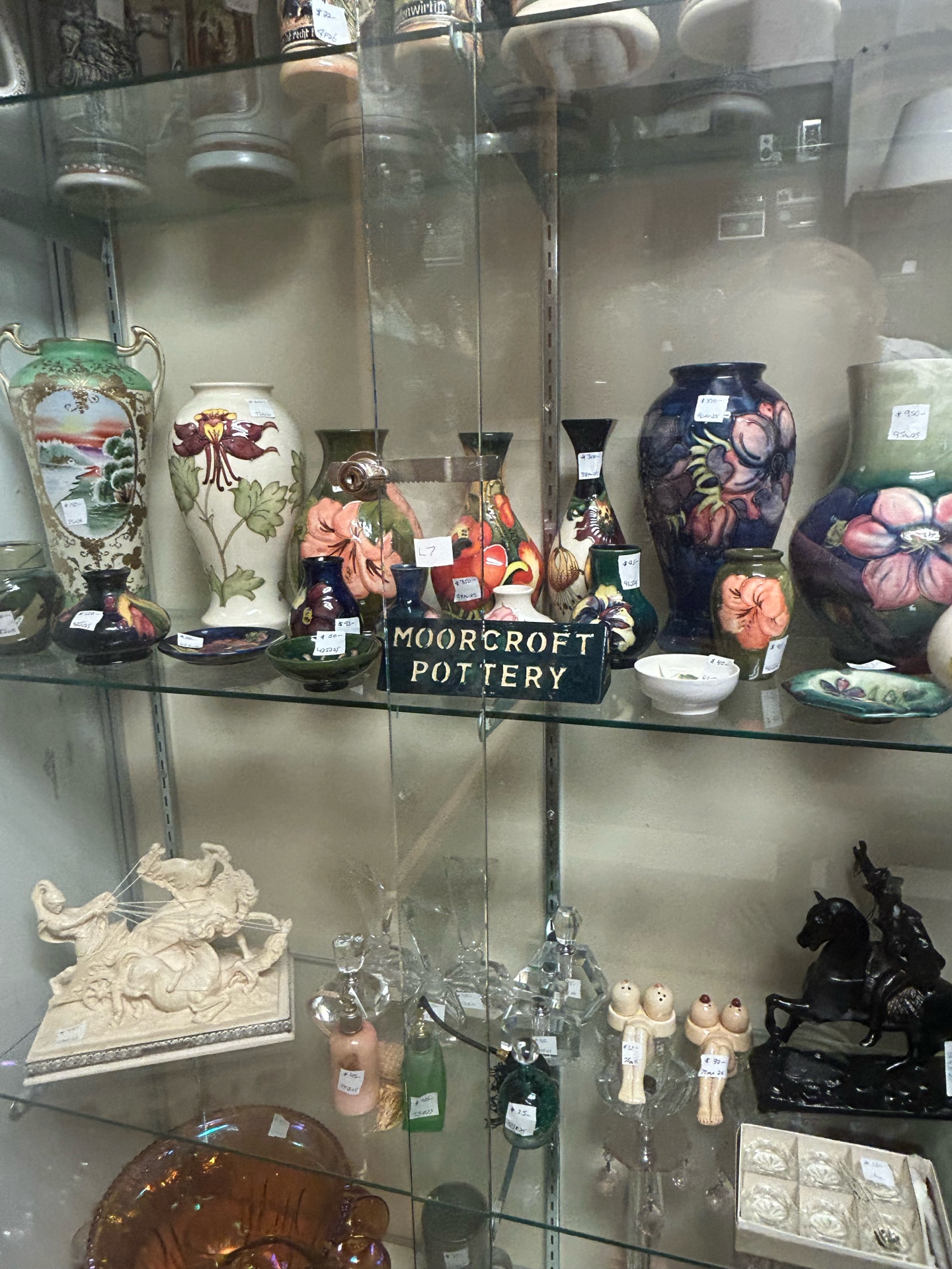 Moorcroft pottery collection in display case at Krave Antiques Regina